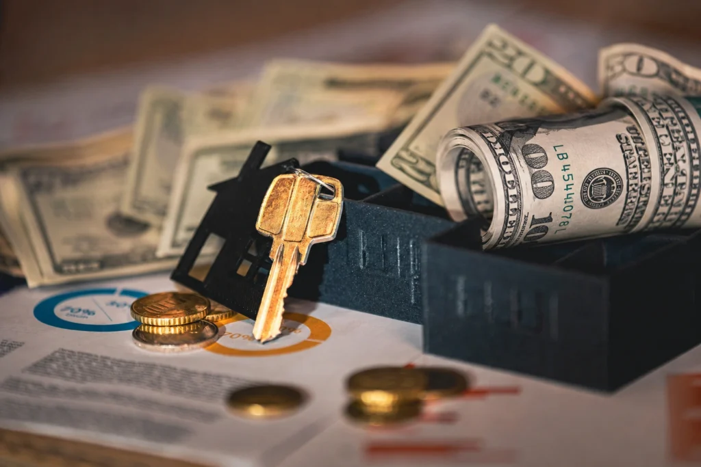 Coins, US bank notes and a key on a table